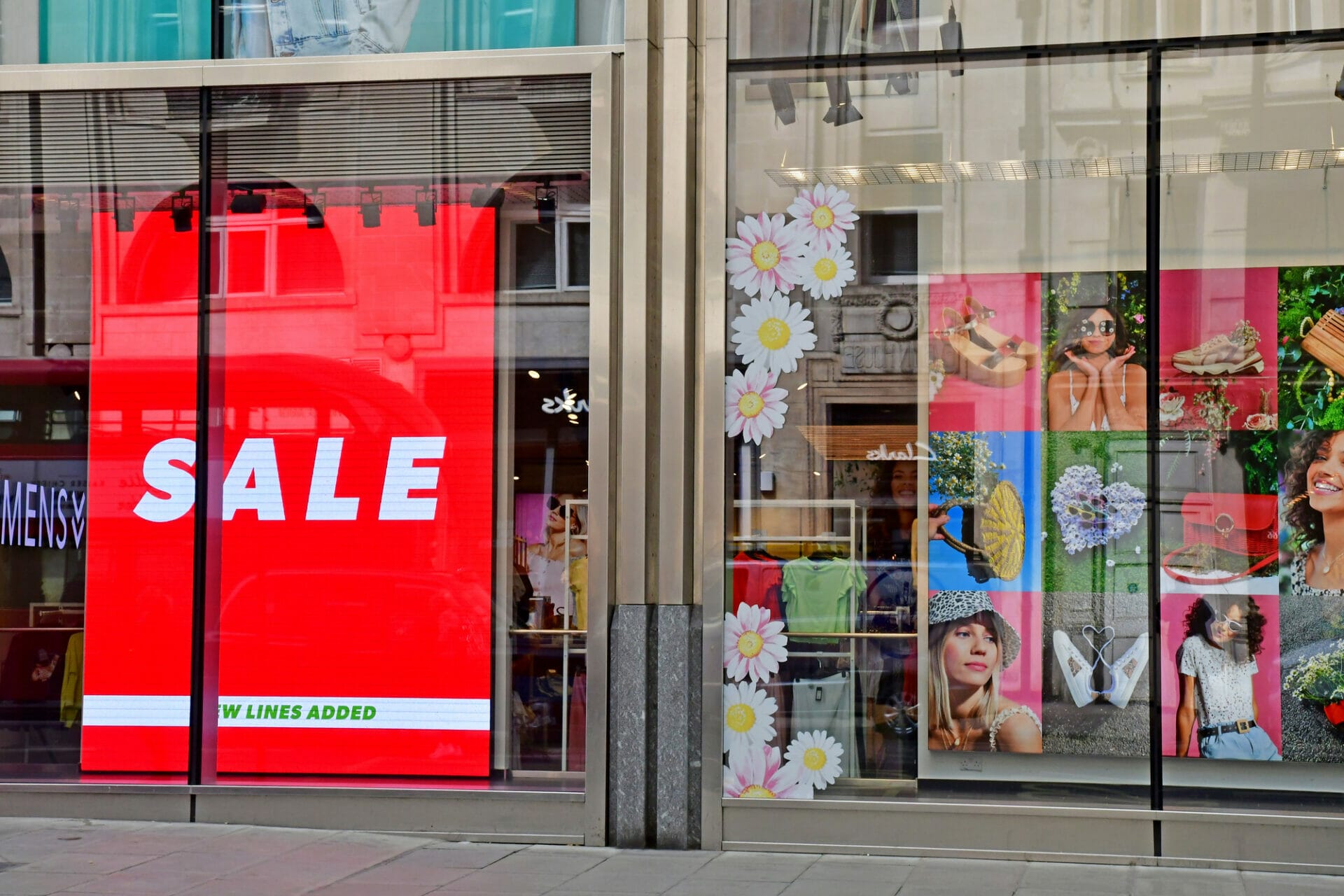 digital signage in front of a retail store saying Sale