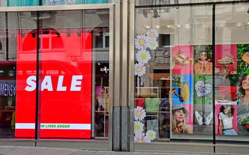 digital signage in front of a retail store saying Sale